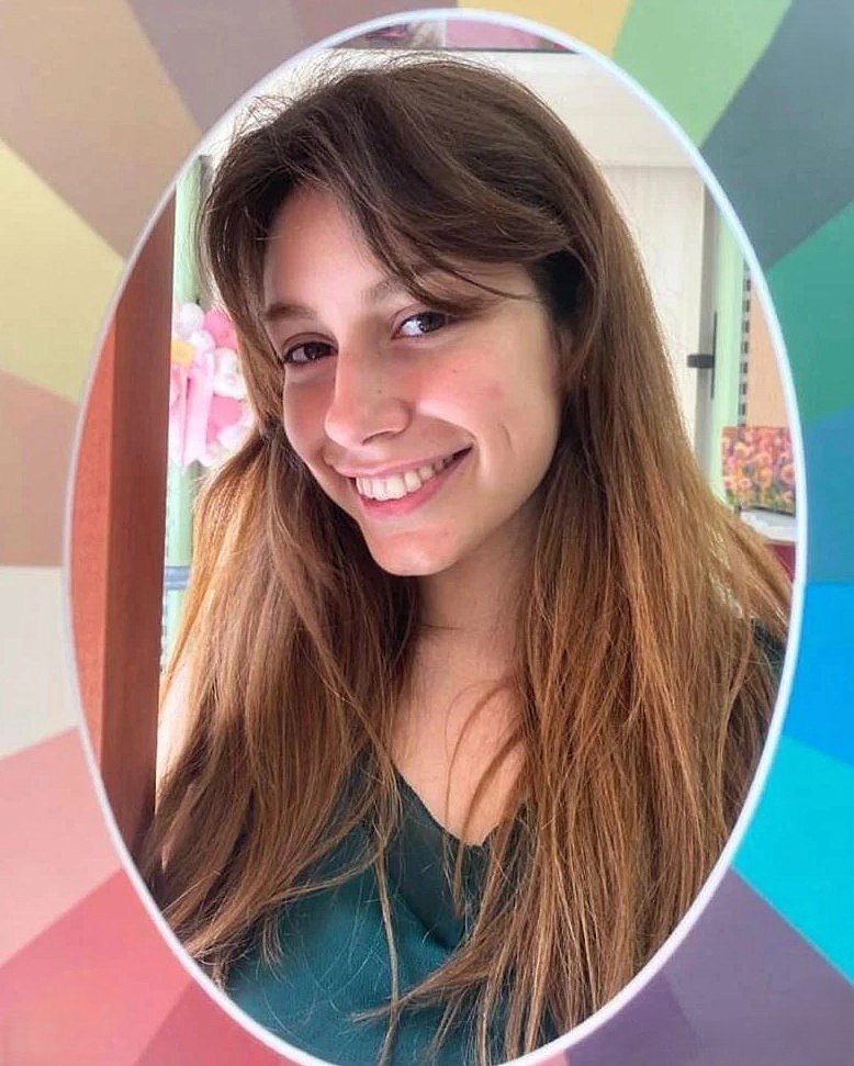 Donna sorridente con capelli castani, armocromia di sfondo colorato